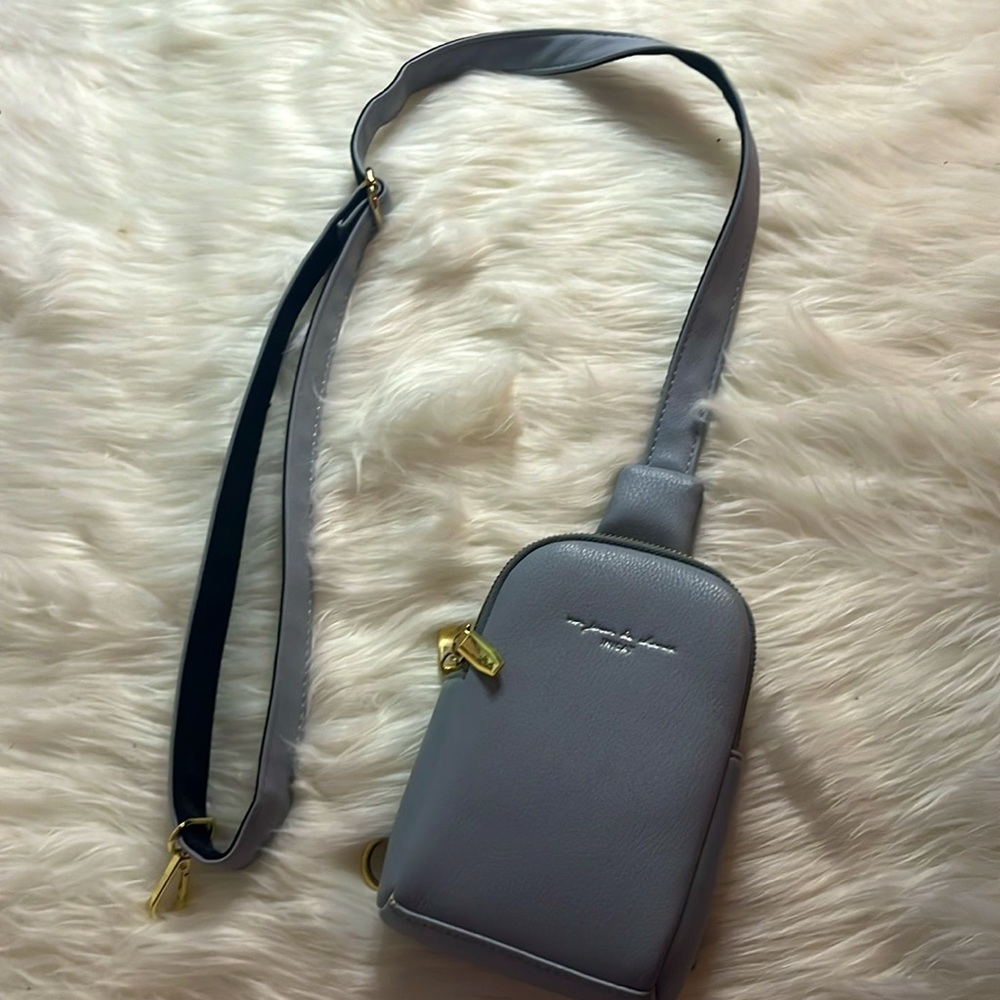 baby blue inicat crossbody bag with gold zippers and clip